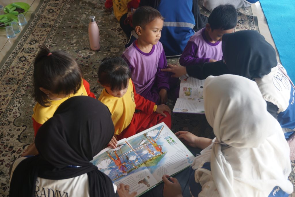 Pembacaan dongen oleh mahasiswa KKN 310 UIN Jakarta kepada anak-anak TK Ar-Royyan dalam acara yang digelar di Yayasan Oemah Daon, Rajeg, Kabupaten Tangerang, pada Sabtu, 8 Agustus 2026. (Sumber foto: Dokumentasi pribadi)